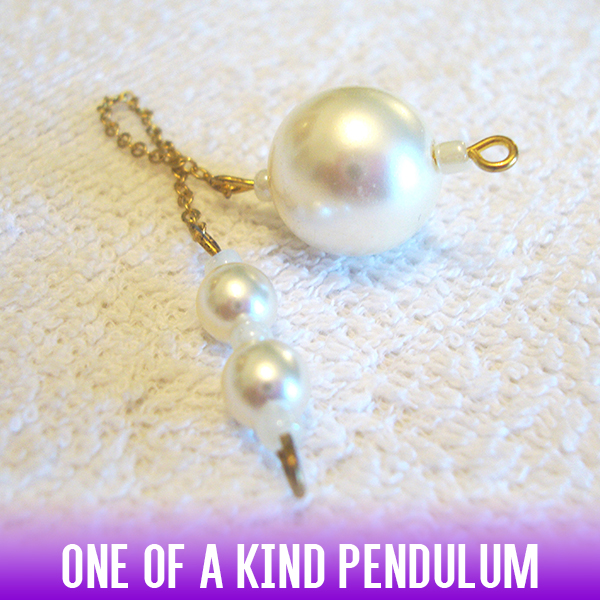 A dowsing pendulum with round imitation pearl bead and an easy-to-hold handle on a gold chain. Simplicity at its best.