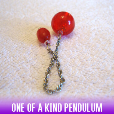 A dowsing pendulum made of cherry red glass blown beads and a silver chain. The ultimate candied red apple of sin.