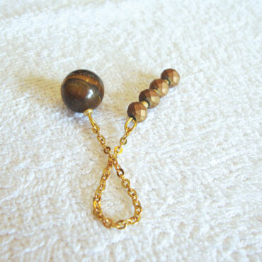 An Eye of the Tiger Round Ball Pendulum with a 4 Faceted Copper Bead Handle and a golden chain