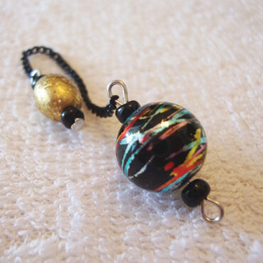 Hand-painted black dowsing ball pendulum with whirlwind metallic stripes and a sparkly gold bead handle and black chain