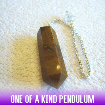 A dowsing pendulum of natural agate stone in a faceted column style with a long antique chain.