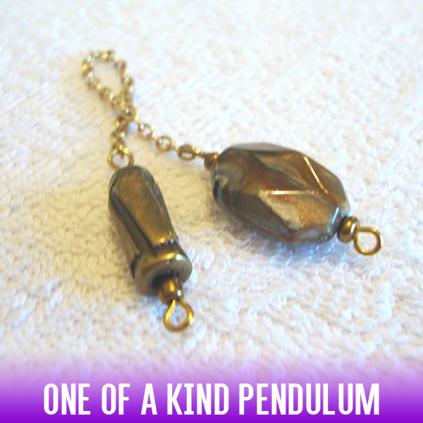 Α dowsing pendulum made of a copper metallic rod with an easy-to-use acrylic handle on a gold chain