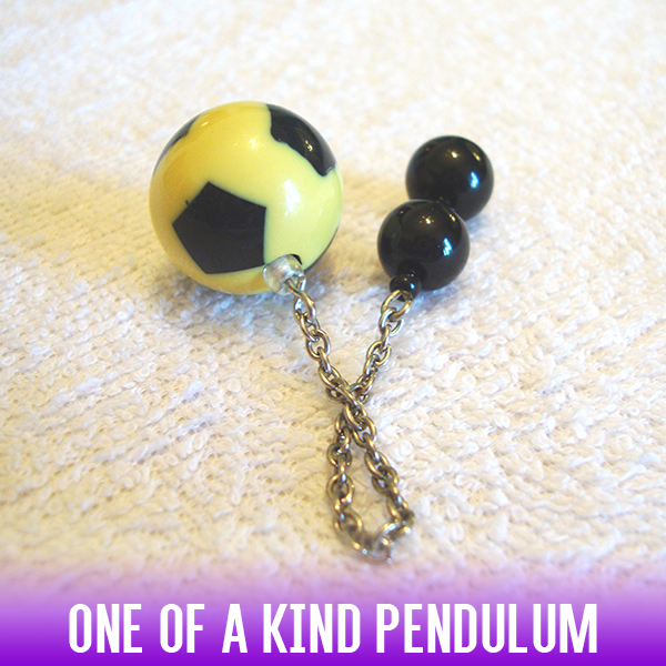 A soccer-ball style yellow & black acrylic bead dowsing pendulum with an easy-to-use handle of 2 black acrylic beads and a silver chain.