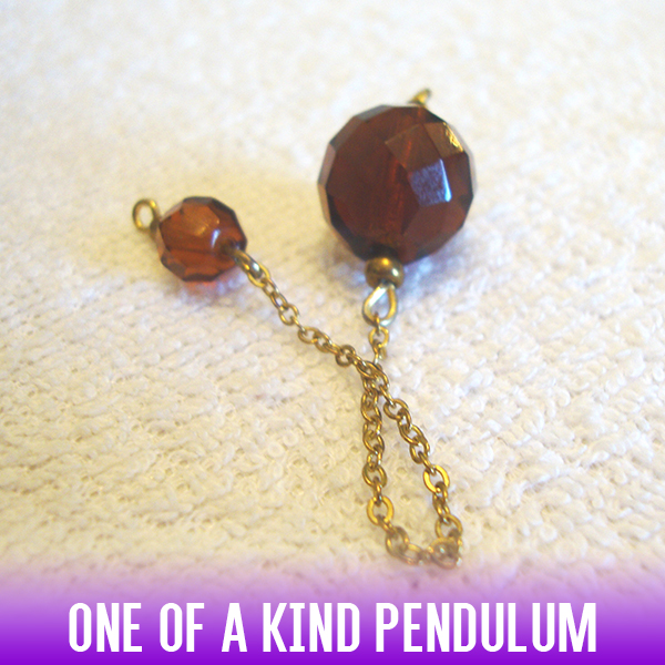 A down-to-earth, dark sugar-colored, faceted sphere bead dowsing pendulum on a golden chain.
