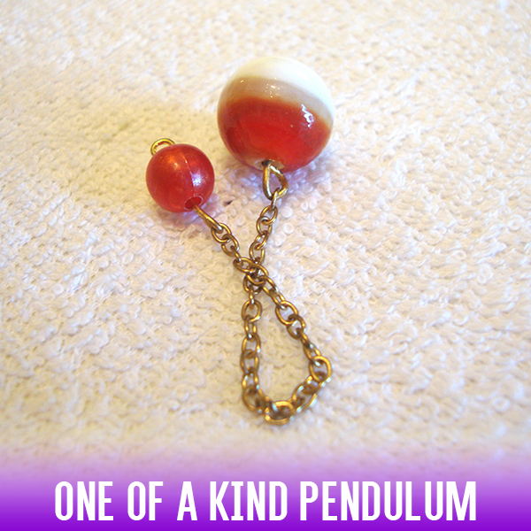 A red, white & gold glass lamp-work ball bead dowsing pendulum on a golden chain.