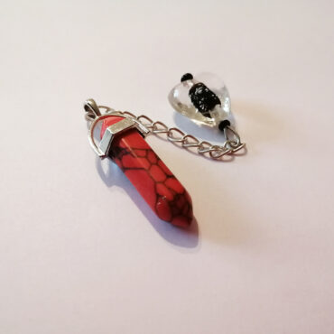 Red turquoise hexagonal column pendulum with a silver chain and a clear and black glass heart-shaped handle