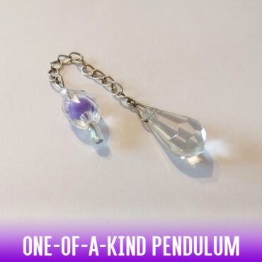 A one-of-a-kind dowsing pendulum with clear multi-faceted pointed column crystal and a two-tone faceted clear & lilac round acrylic ball handle on a silver chain.
