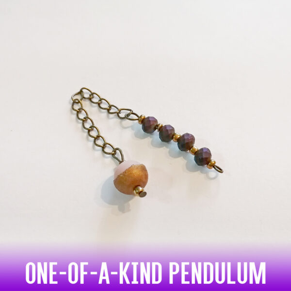 A one-of-a-kind two-tone pink and copper acrylic ball dowsing pendulum with a faceted iridescent purple faceted 4 bead handle and an antique gold chain