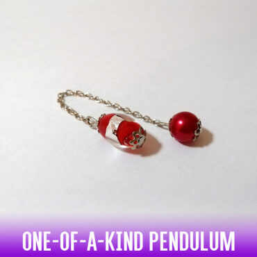 A dowsing pendulum made with a truly red and silver foil luminous Murano lampwork oval bead and silver end caps. A silver chain and a red acrylic sphere bead, complete the look.