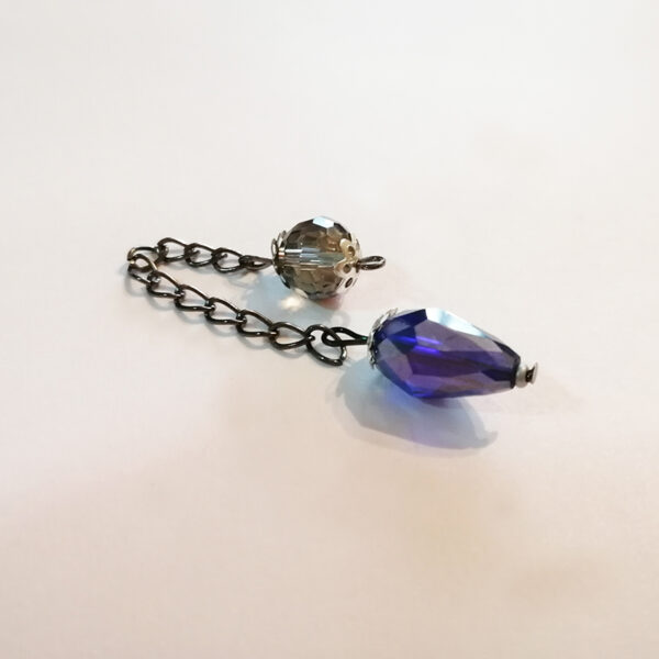 A one-of-a-kind petite drop-shaped dowsing pendulum made with crystal glass faceted beads with silver end caps on an antique silver chain.