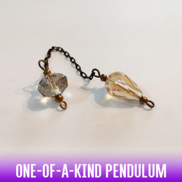 A one-of-a-kind petite drop-shaped dowsing pendulum made with crystal glass faceted beads with silver end caps on an antique two-tone chain.