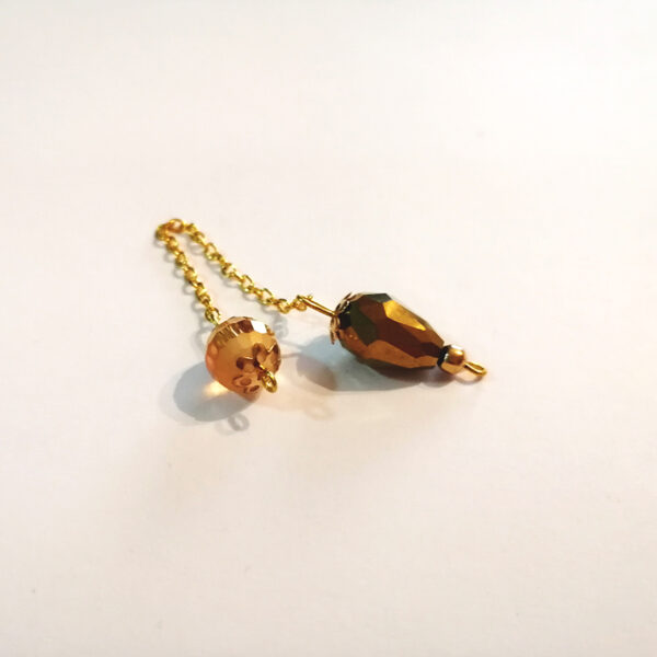 A petite drop-shaped dowsing pendulum made with crystal glass faceted beads with gold end caps on an gold chain.