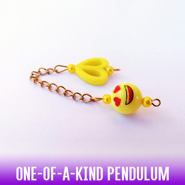 A one-of-a-kind yellow happy crazy-in-love face acrylic bead with a yellow heart shaped flat bead handle on a gold chain