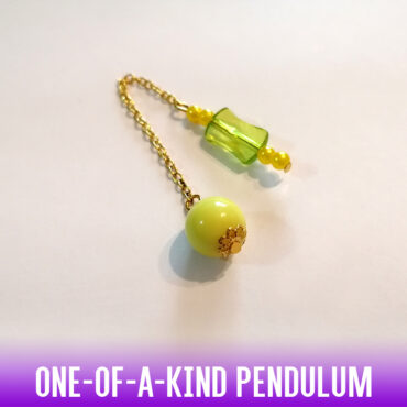 A unique lightweight dowsing pendulum with a yellow acrylic bead and a greenish yellow flat handle, gold trims and a gold chain.