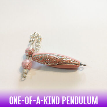 A one-of-a-kind lightweight dowsing pendulum with a metal enlaced pink acrylic elongated oval bead, a silver chain and a 2 pink acrylic striped beads with interchanging clear spacer beads for a firm grip. 