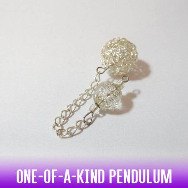 A popular dowsing pendulum of a silver hollow twist wire ball, with a carved silver-dusted round acrylic bead at the handle and a silver chain 