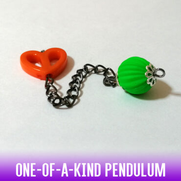 A one-of-a-kind dowsing pendulum with an acrylic, matte neon green corrugated rubber bead on a silver chain with silver end caps. On the handle, we have a bright orange hollow acrylic heart bead. A fun dowsing tool for the young or the young at heart.